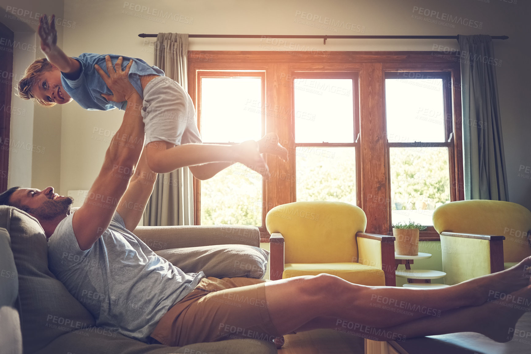 Buy stock photo Shot of a man spending some quality time with his son at home