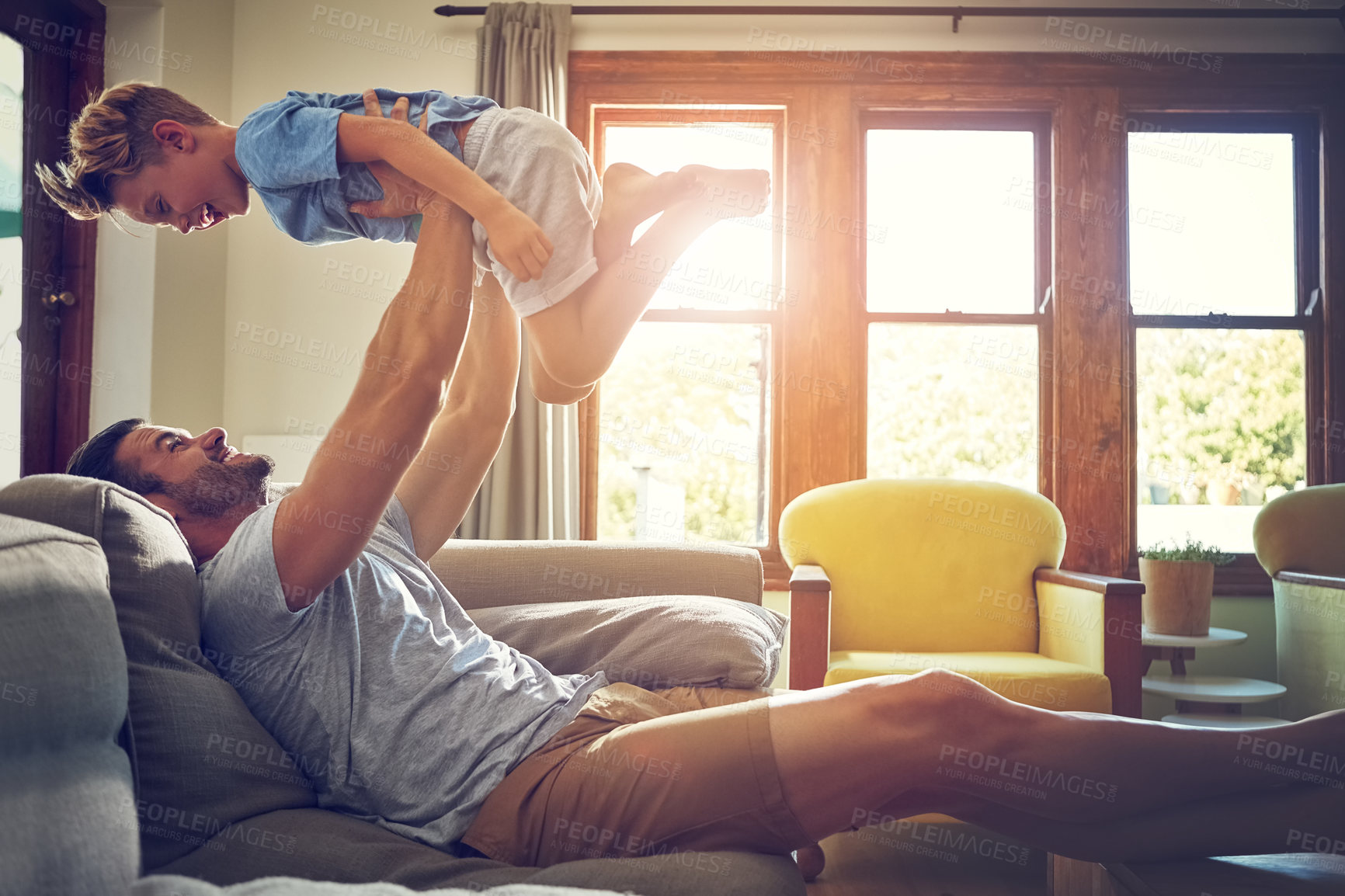 Buy stock photo Shot of a man spending some quality time with his son at home