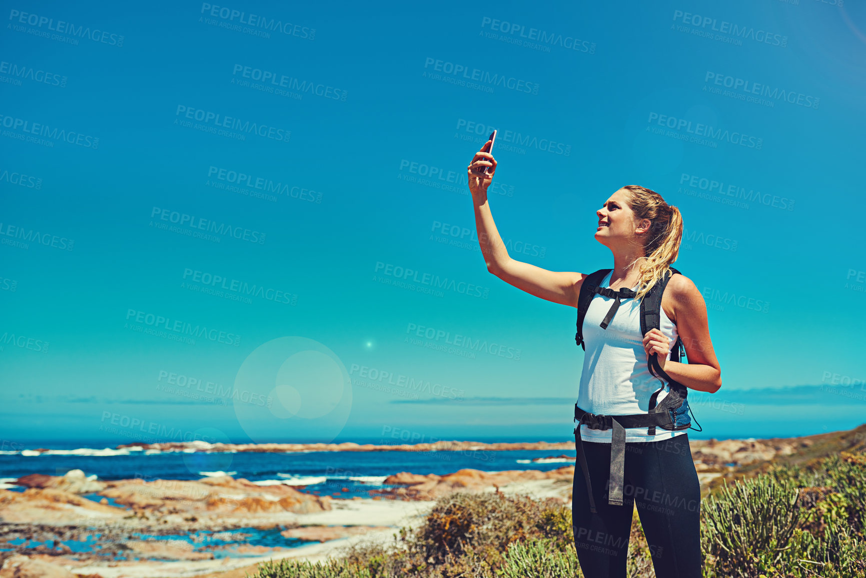 Buy stock photo Shot of a sporty young woman using her cellphone outdoors