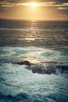 Buy stock photo Shot of ocean waves crashing against boulders on the seashore