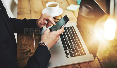 Buy stock photo Cropped shot of a businessman using a mobile phone and laptop at his work desk