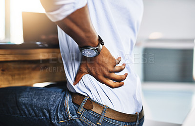 Buy stock photo Shot of a unrecognizable businessman suffering from back pains while trying to work in the office