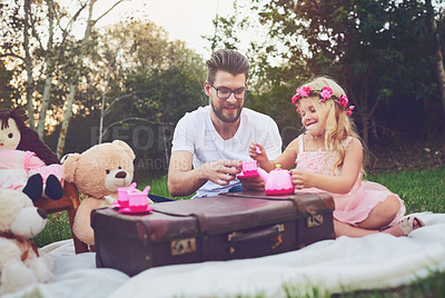Buy stock photo Shot of a cheerful daughter and father having a tea party with a bunch of stuffed toys in the middle of a garden
