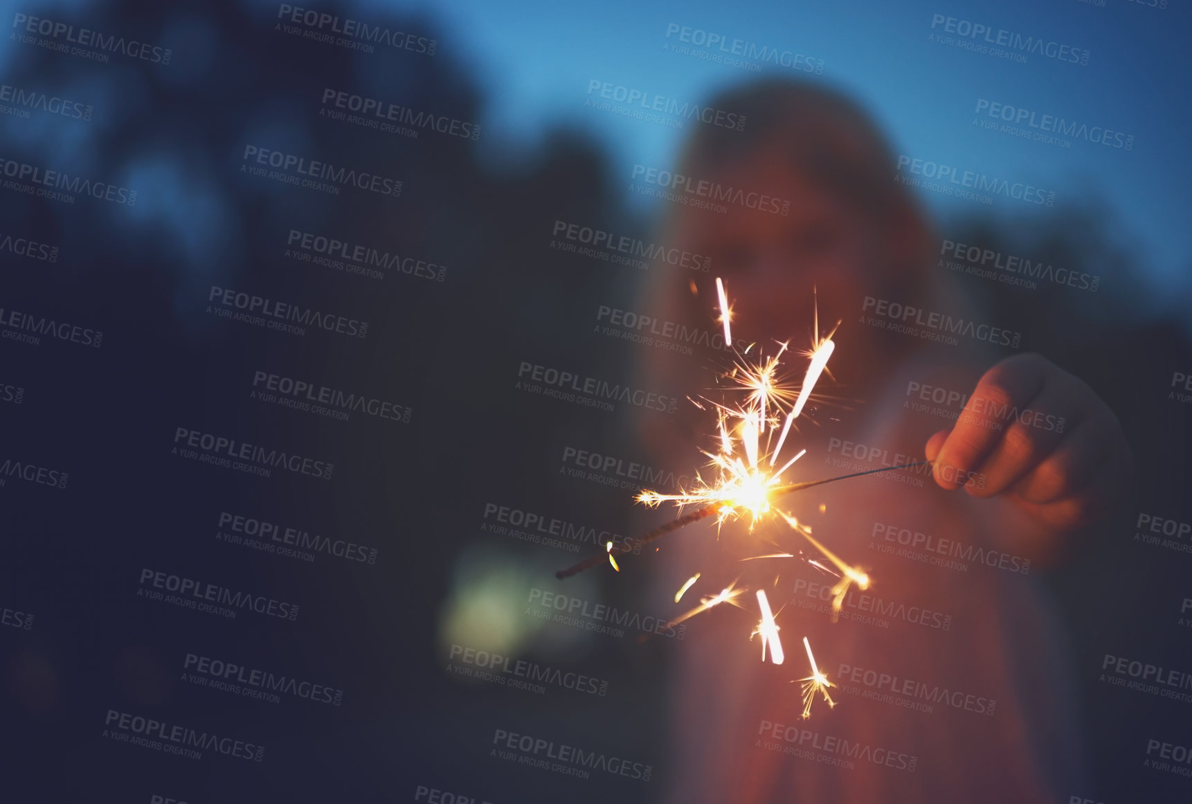 Buy stock photo Shot of a unrecognizable little girl playing with a sparkler at night time outside in nature