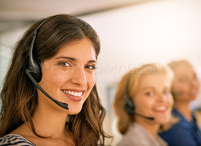 Buy stock photo Cropped portrait of a young woman working alongside her colleagues in a call center