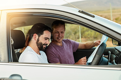 Buy stock photo Shot of a group of young friends getting ready to drive to their destination in their vehicle while looking at a map