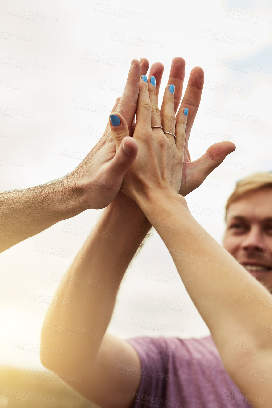 Buy stock photo Shot of a group young friends engaging in a high five outside next to a road