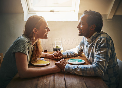 Buy stock photo Love, couple and holding hands at home on table, talking and bonding together. Valentines day, romance diversity and affection of man and woman on date, having fun and enjoying quality time in house.