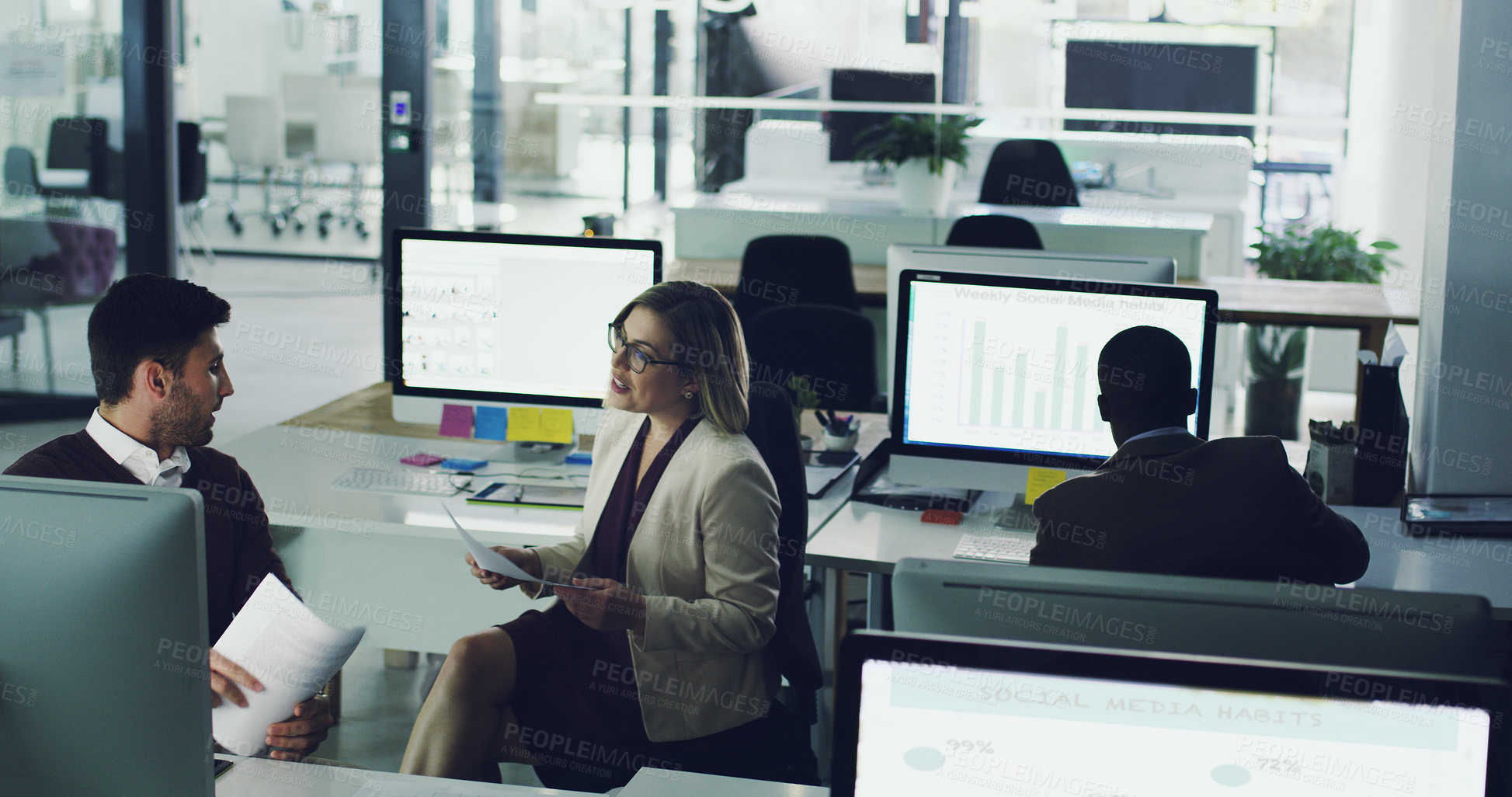 Buy stock photo High angle shot of two businesspeople discussing some paperwork in their office