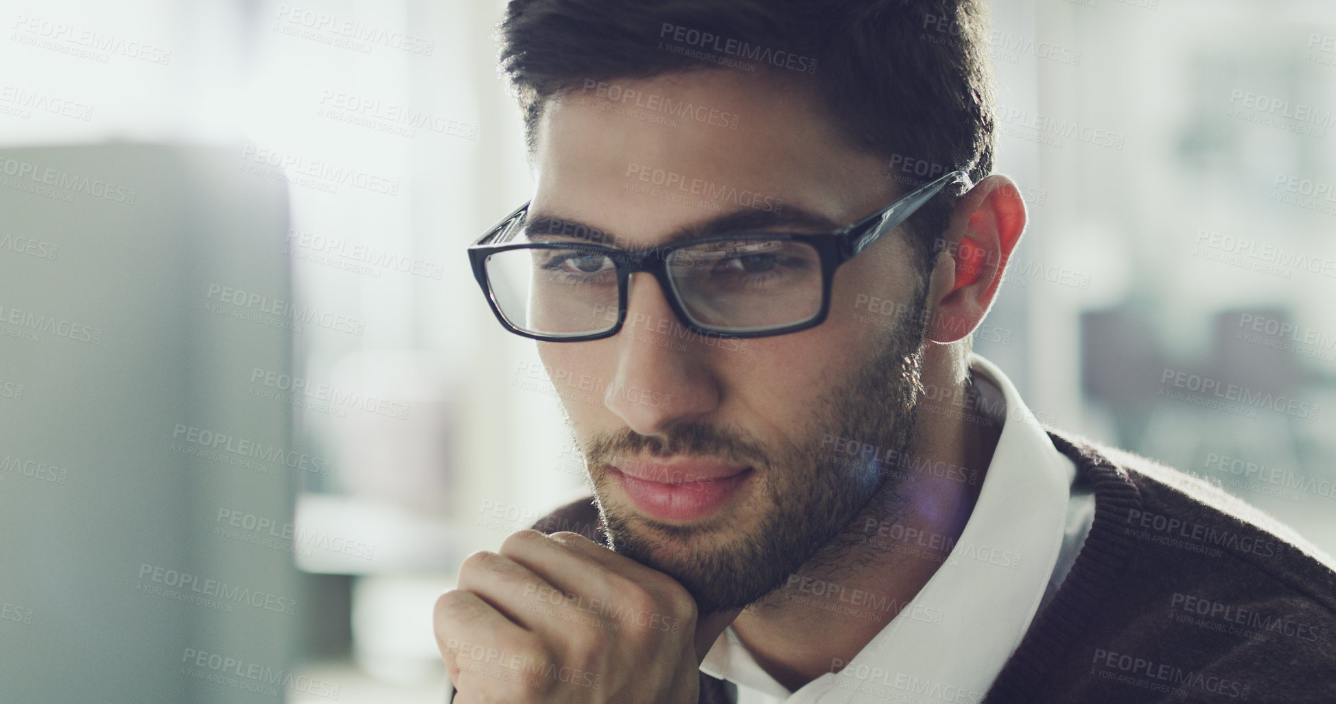 Buy stock photo Cropped shot of a handsome young businessman working on his computer in the office