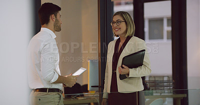 Buy stock photo Cropped shot of two businesspeople talking while standing in the office lobby