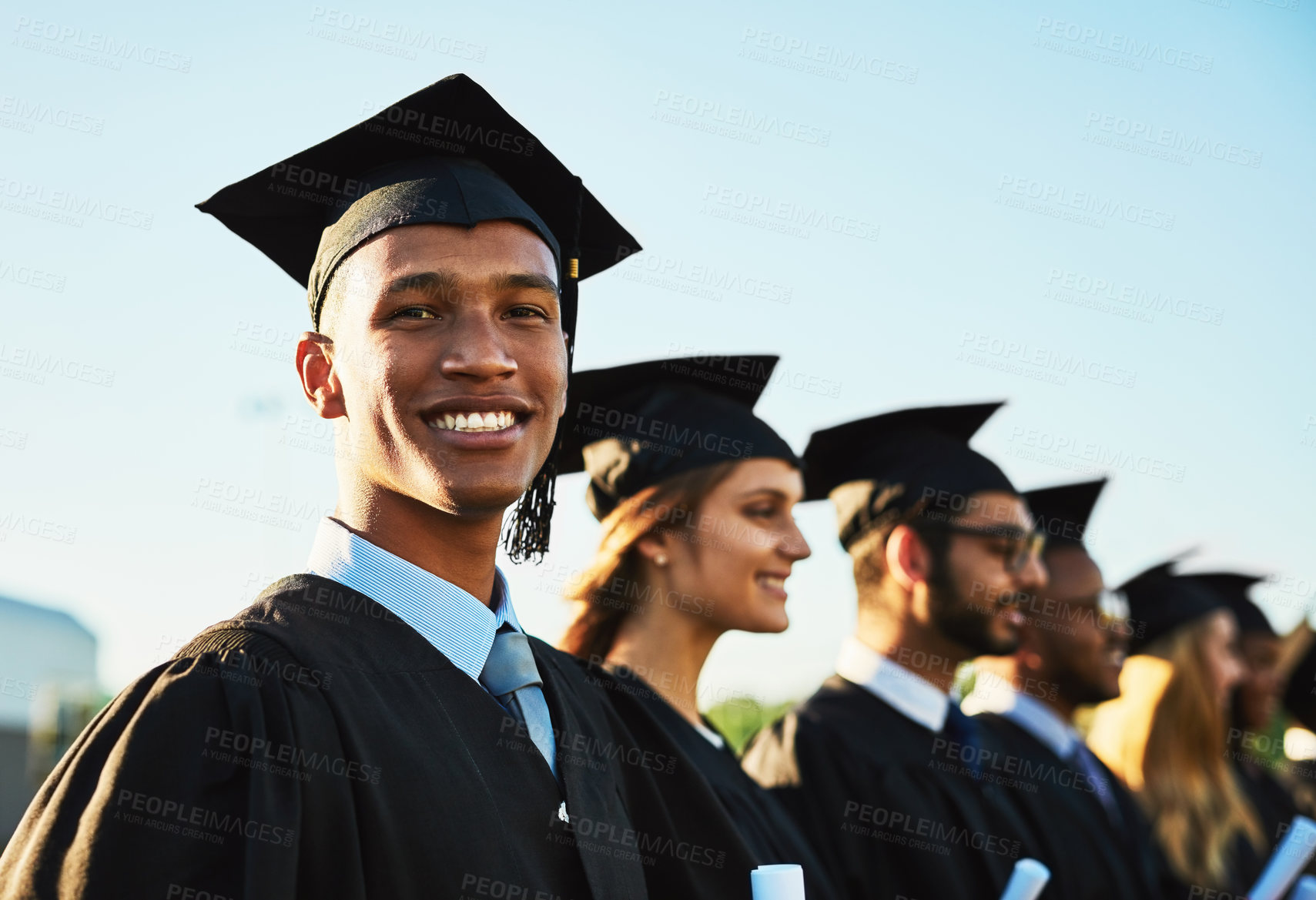 Buy stock photo Black man, student smile and graduation ceremony with class group for education, qualification or future. Portrait of happy person and scholar with goals for diploma, certificate or degree on campus