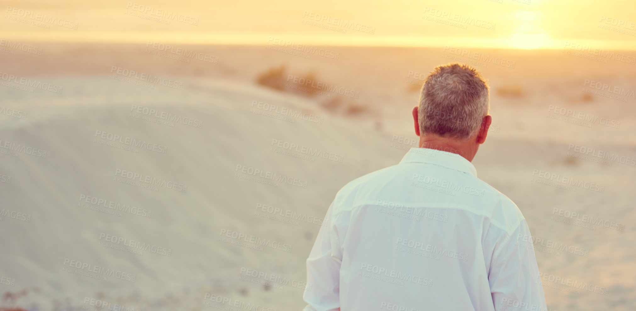 Buy stock photo Rearview shot of mature man walking on the beach at sunset