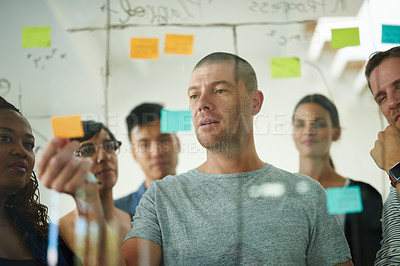 Buy stock photo Business teamwork meeting using notes to brainstorm and work together. Casual workplace team planning and thinking of creative ideas. Office workers planning a group work project