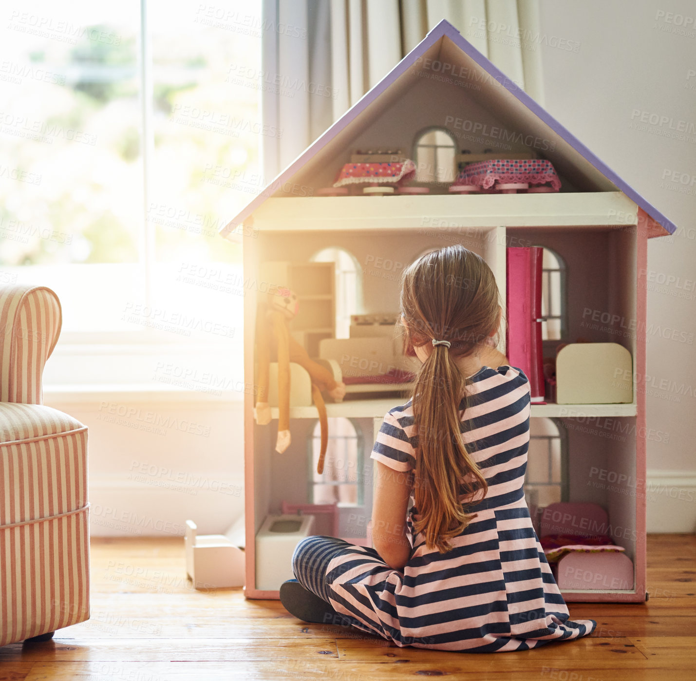 Buy stock photo Dollhouse, home and kid play with fun game, imagination and dream on floor in living room alone. Child from back and tiny furniture for story development, learning and game or toys for social skills