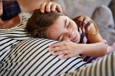 Buy stock photo Shot of a young girl cuddling her pregnant mother’s stomach