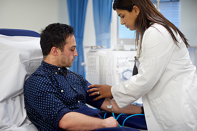 Buy stock photo Shot of a doctor checking a patient's blood pressure in a hospital