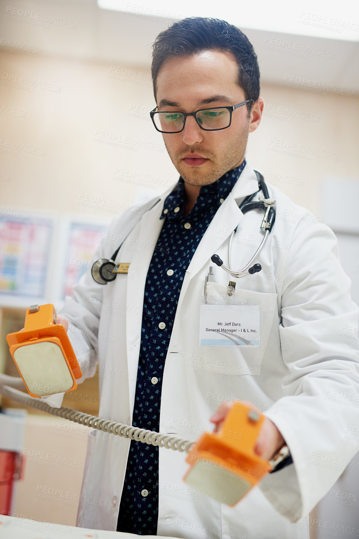 Buy stock photo Shot of a doctor using a defibrillator in a hospital
