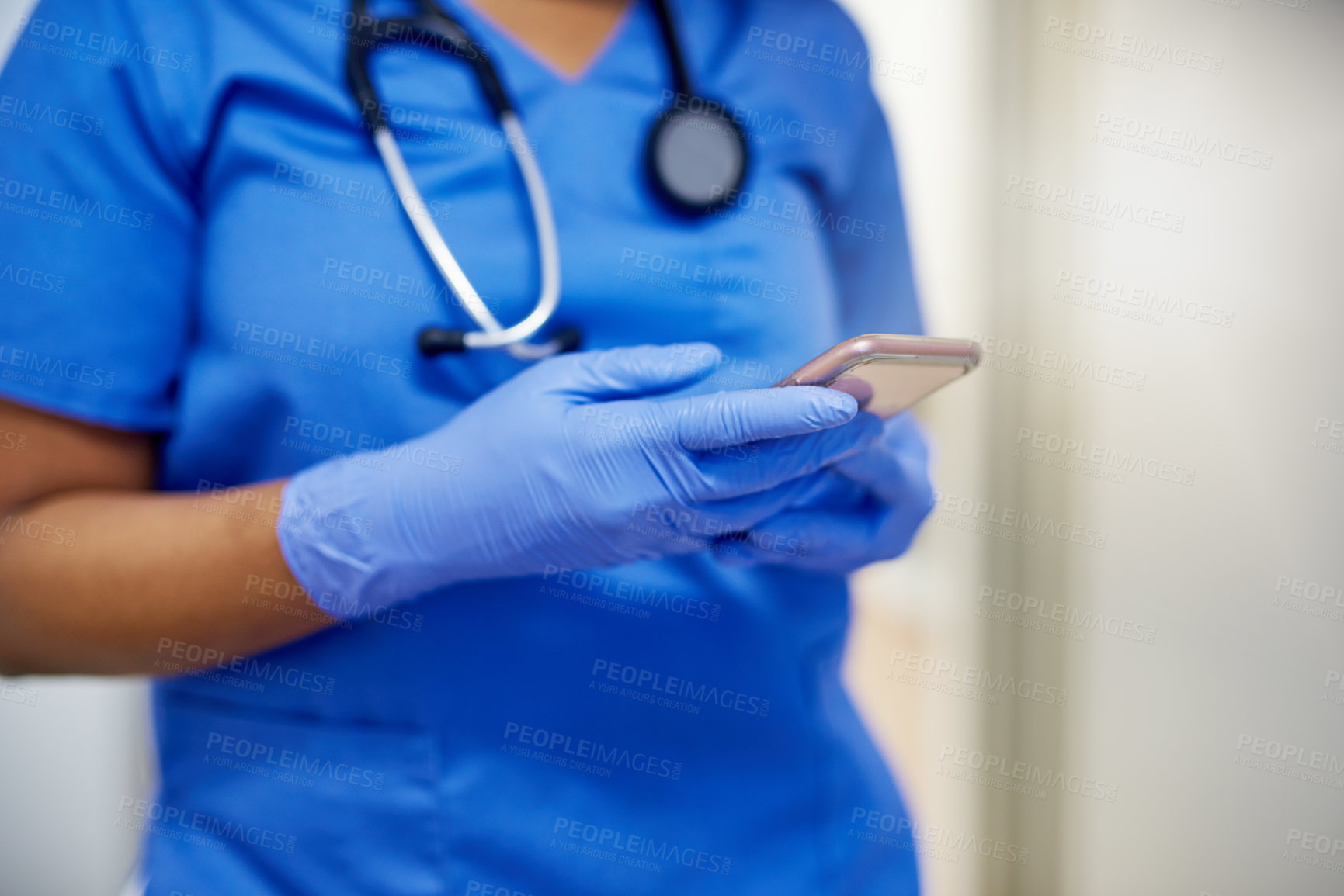 Buy stock photo Shot of an unrecognisable surgeon using a cellphone in a hospital
