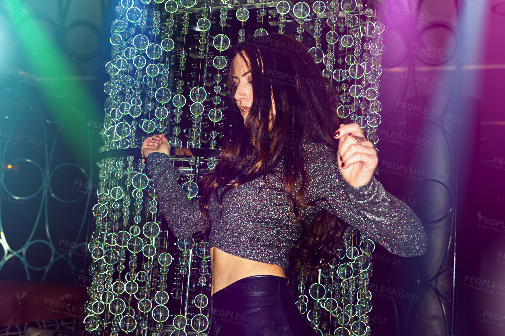 Buy stock photo Cropped shot of a young woman enjoying herself on the dance floor of a nightclub