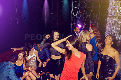 Buy stock photo Shot of a group of young adults enjoying themselves while out in a nightclub