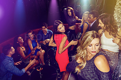 Buy stock photo Shot of a group of young adults enjoying themselves while out in a nightclub