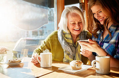 Buy stock photo Senior woman, daughter browsing and smile with smartphone in cafe for memories with social media. Funny, post and relaxing in restaurant with coffee, muffin and sunshine in retirement with excited.