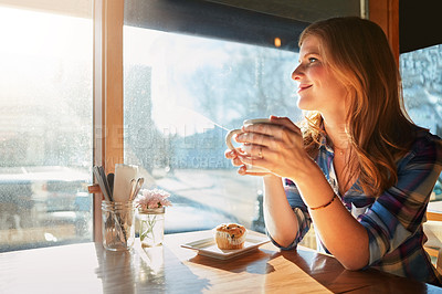 Buy stock photo Shot of an attractive young woman enjoying a cup of coffee in a cafe