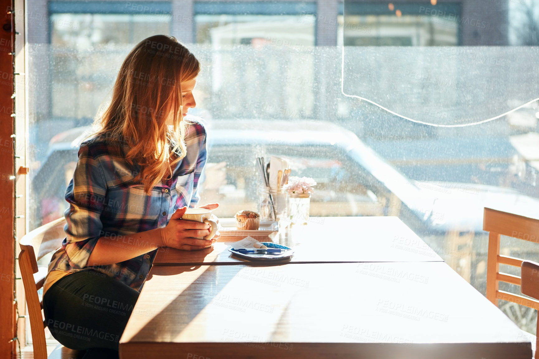 Buy stock photo Shot of an attractive young woman enjoying a cup of coffee in a cafe