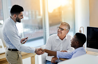 Buy stock photo Shot of a motivated group of businessmen greeting each other in the office at work