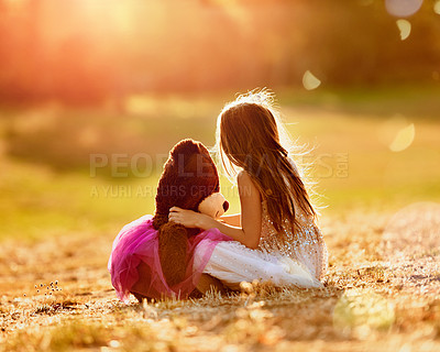 Buy stock photo Shot of an adorable little girl playing with her teddybear outdoors