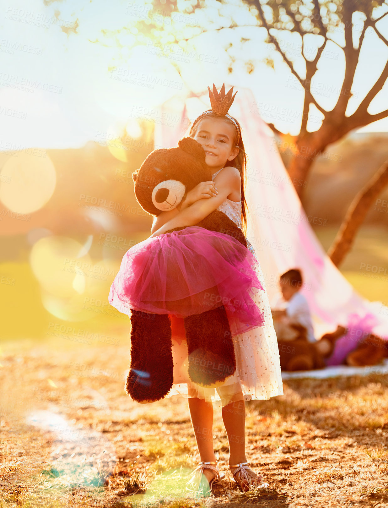 Buy stock photo Portrait, princess or girl with teddy bear in nature for love, orphan or toy for support, care or therapy. Hug, sun flare or kid in park with stuffed animal, tiara costume and donation gift in Spain