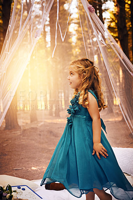 Buy stock photo Shot of a happy little girl looking into the distance while standing outside in the woods