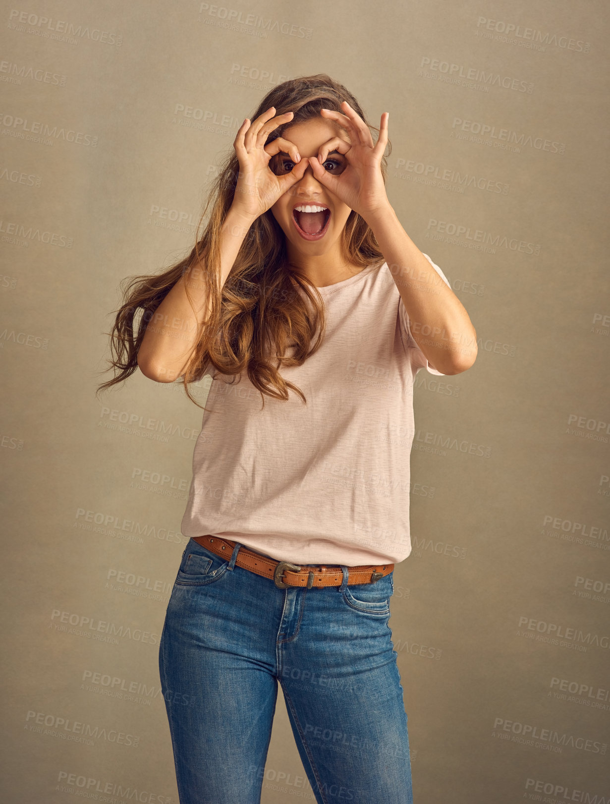 Buy stock photo Woman, portrait and ok sign by eyes on studio background with smile, tongue and excited for fun. Female person, face and hand binoculars for positive attitude, silly and playful personality with icon