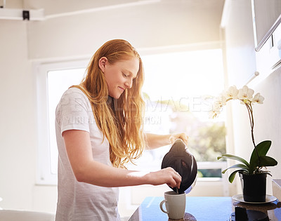 Buy stock photo Shot of a young woman making a hot drink in the kitchen at home