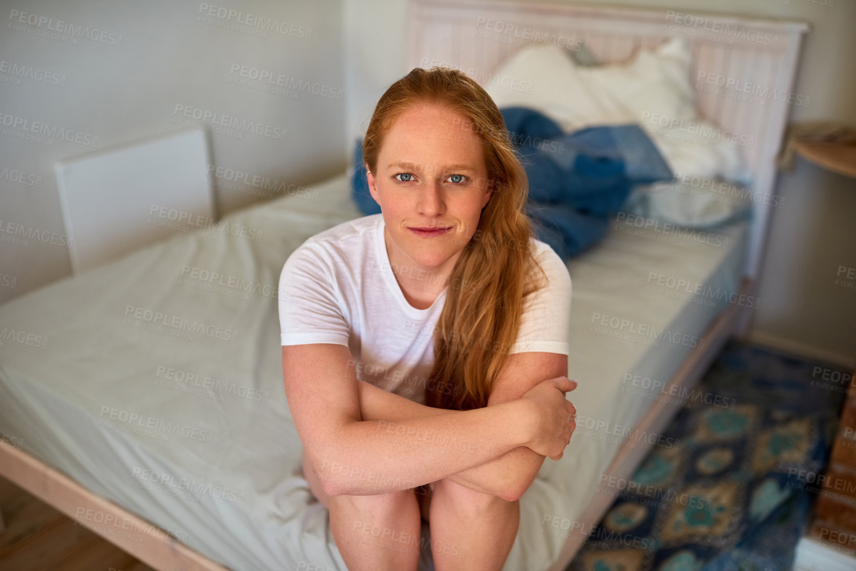 Buy stock photo Shot of a young woman sitting on her bed in the bedroom at home
