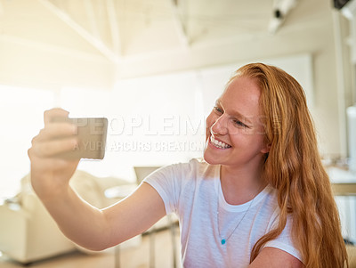 Buy stock photo Shot of a young woman taking a selfie at home