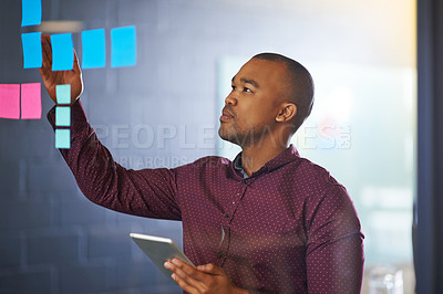 Buy stock photo Shot of a male designer working on a glass wall in the office