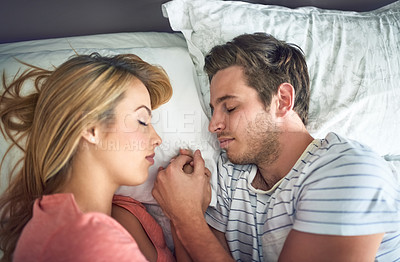 Buy stock photo Shot of a peaceful young couple sleeping face to face with each other in bed