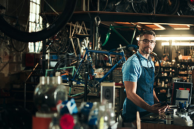 Buy stock photo Man, portrait and bicycle technician with tools in small business for fix, repair or maintenance. Young male person, cycle engineer or bike mechanic with equipment for job or career at workshop