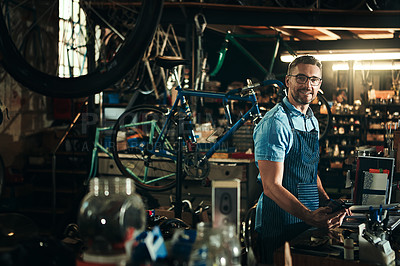Buy stock photo Happy man, portrait and bicycle mechanic with tools in small business for fix, repair or maintenance. Young male person, cycle engineer or bike technician with equipment for job or career at workshop