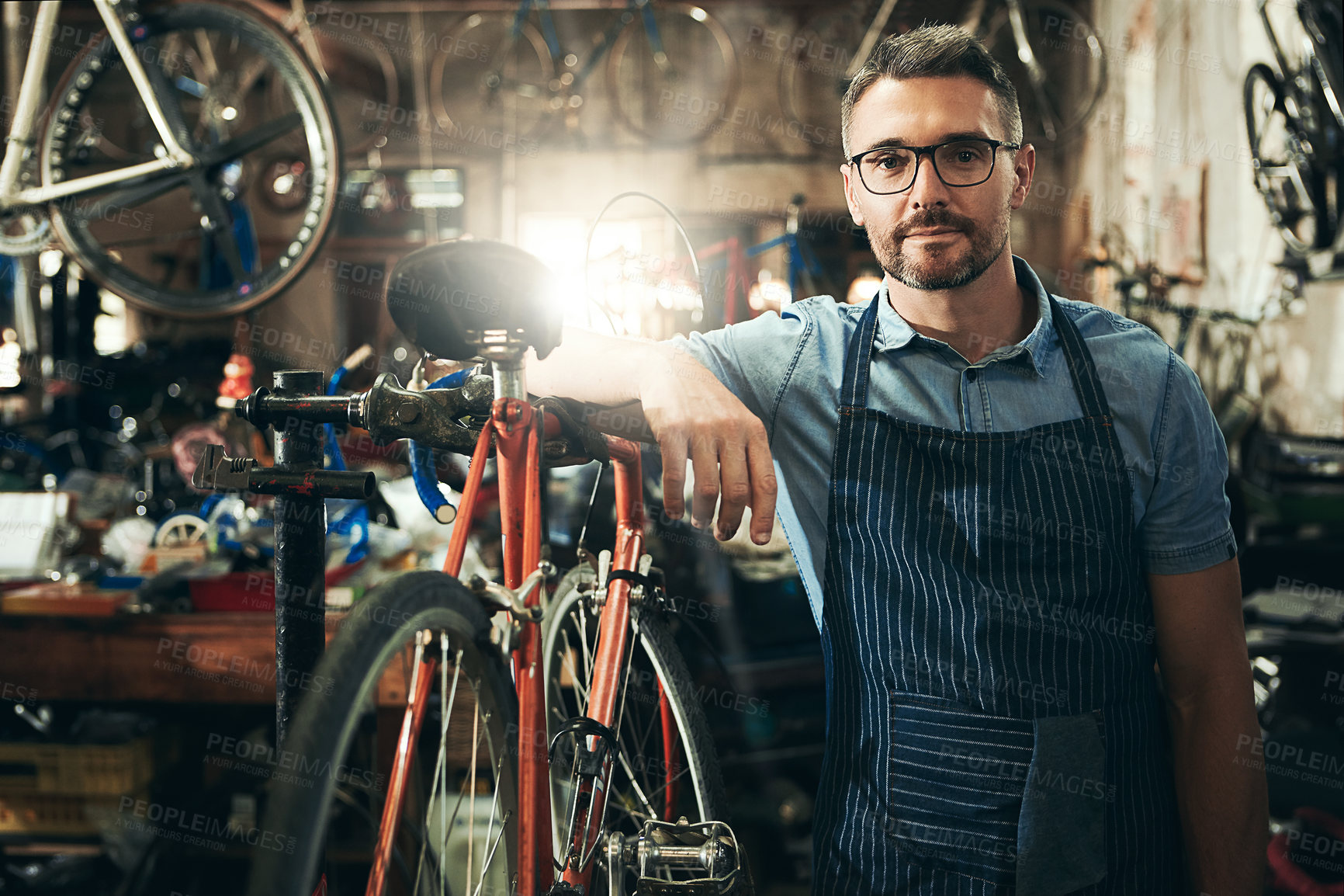 Buy stock photo Man, portrait and entrepreneur at work in bicycle repair shop or maintenance garage. Bike, mechanic and service with a professional confidence for startup, small business and workshop for fixing