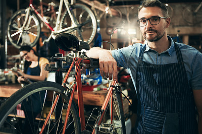 Buy stock photo Portrait, serious man and mechanic in bicycle shop, store and cycling repair startup. Technician service, bike and confident male person, mature worker and professional with glasses in workshop