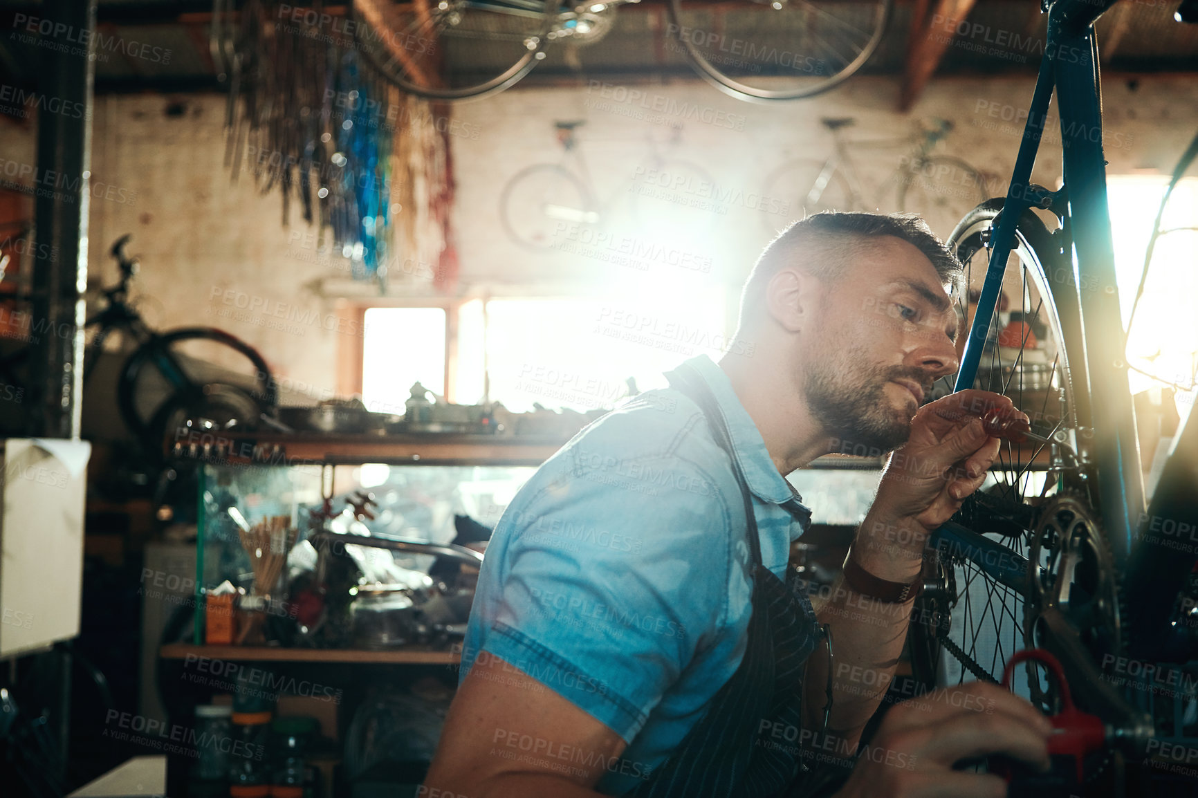 Buy stock photo Tools, mechanic and man fixing bicycle in garage with checking brake, startup business and maintenance service. Mature guy, bike technician and chain inspection in workshop with tire or gear repair