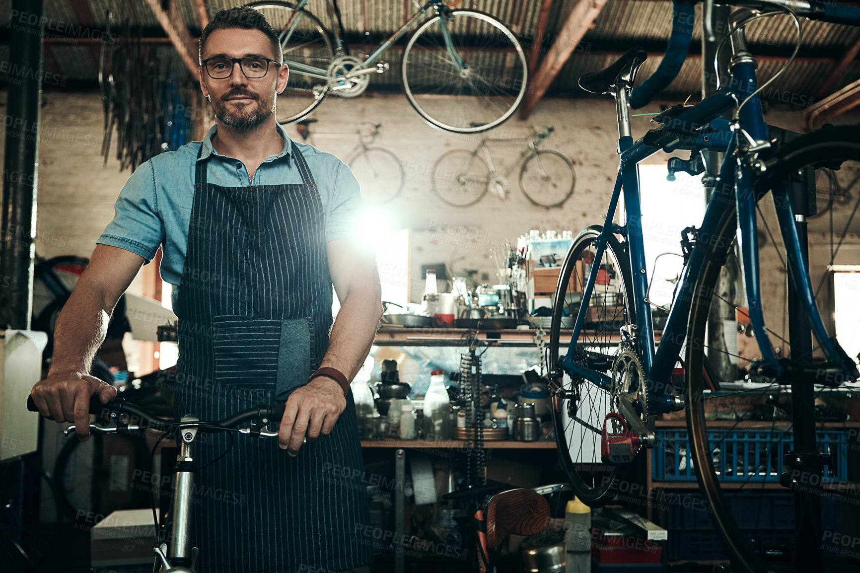 Buy stock photo Portrait of a mature man working in a bicycle repair shop