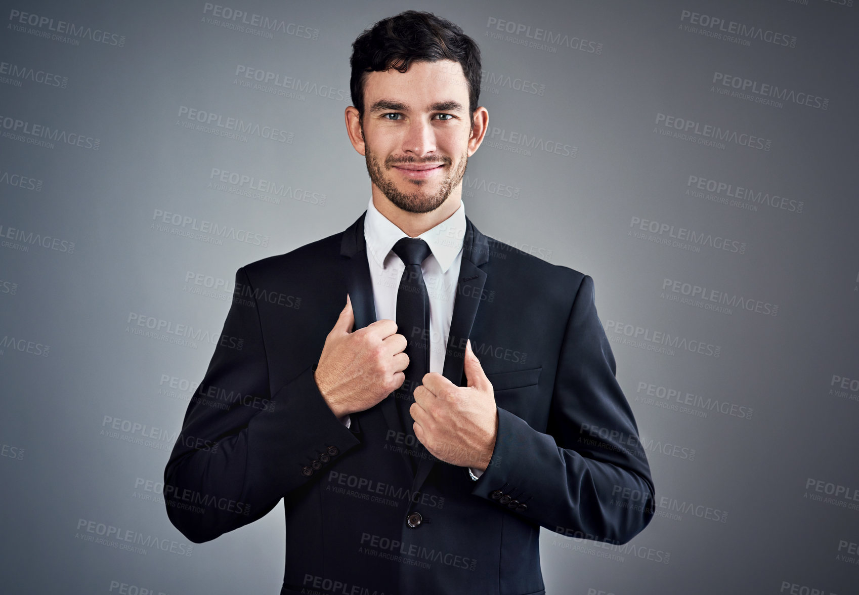 Buy stock photo Studio portrait of a handsome young businessman dressed in a suit against a grey background