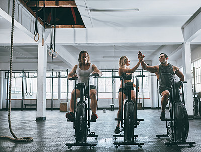 Buy stock photo Shot of three people working out on elliptical machines
