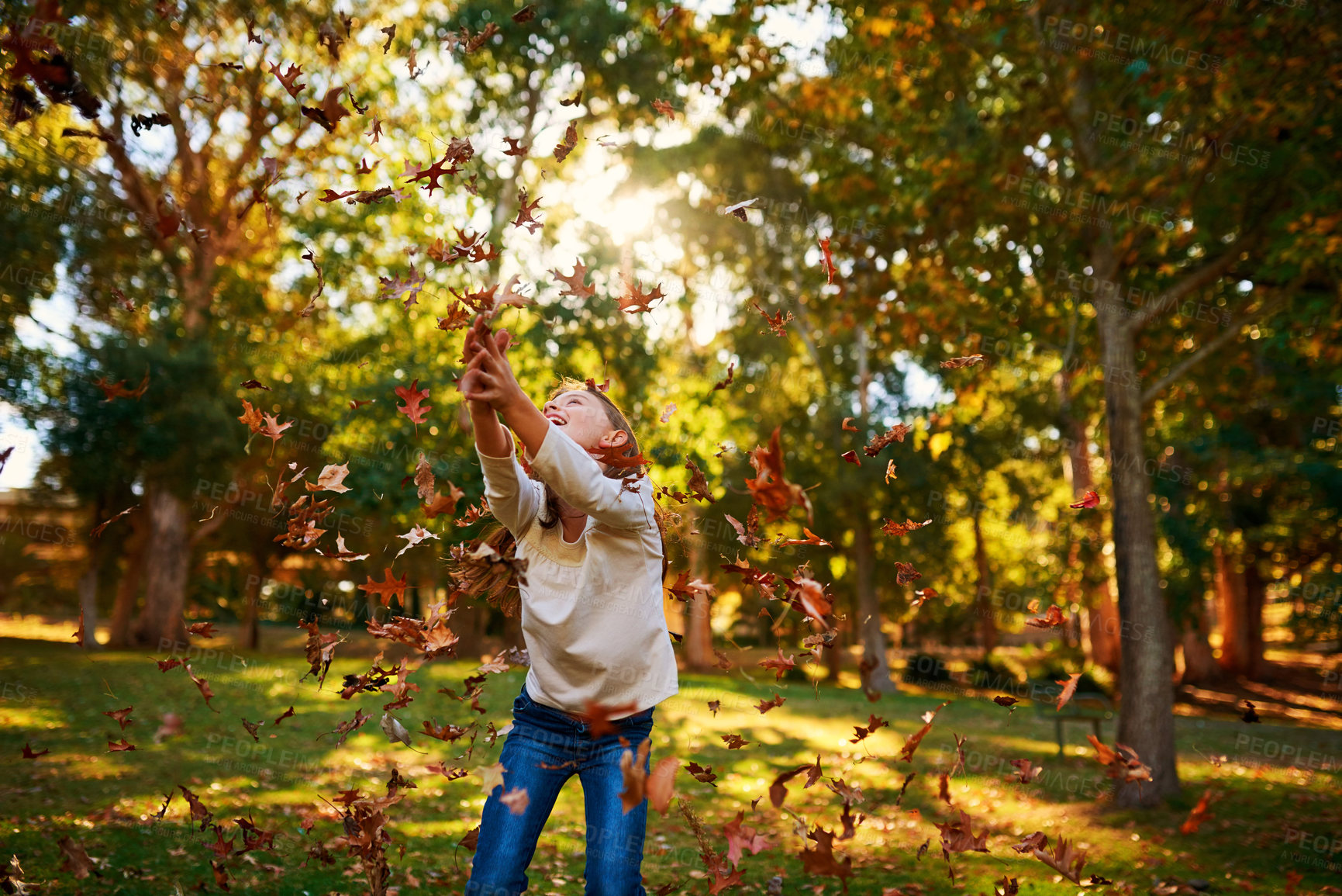 Buy stock photo Girl, child and leaves or catch in park for adventure, fun activity and autumn game with enjoyment outdoor. Kid, happy and excited with freedom, holiday or wellness on grass in nature with sunlight