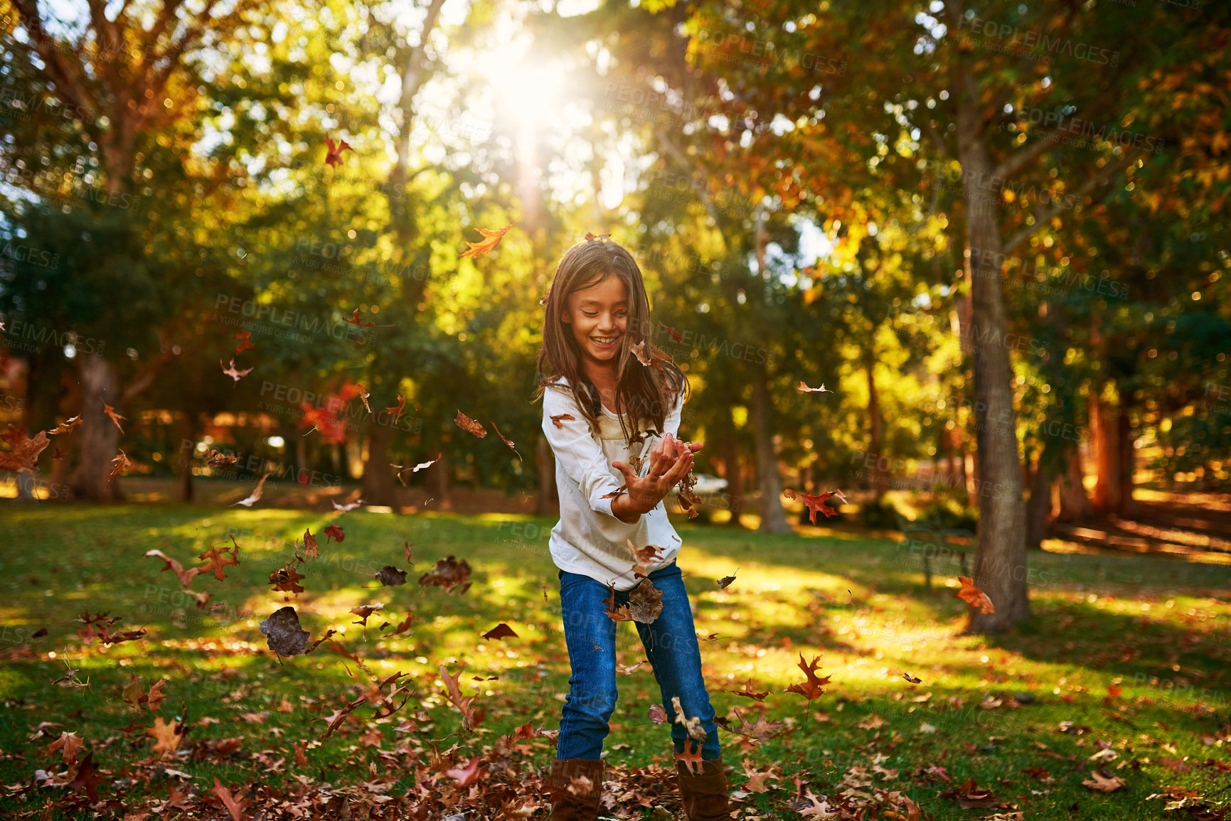 Buy stock photo Girl, kid and leaves or catch in park for adventure, fun activity and autumn game with enjoyment outdoor. Child, happy and excited with freedom, holiday or wellness on grass in nature with sunlight