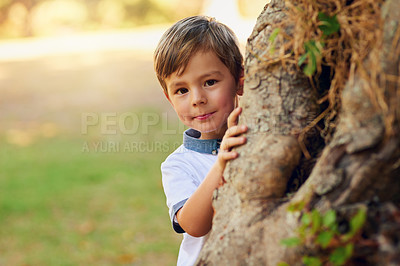 Buy stock photo Shot of a happy little boy playing next to a tree in the park